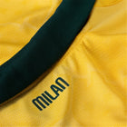 Close-up of a yellow fabric with a green stripe and 'Milan' branding.