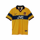 Hinchas Sportswear Store Arsenal 1997-99 retro away jersey. Yellow with navy chest band, JVC sponsor, red Nike swoosh, and Arsenal crest.