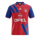 Hinchas Sportswear Store Bayern Munich 1993 retro home jersey. Red with blue sleeves, V-neck, and diagonal blue stripe panels. Features Adidas and Opel logos.