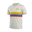 Hinchas Sportswear Store Colombia 100 Years Special Edition Jersey. Off-white, short-sleeve football jersey with yellow, blue, and red stripes across the chest. Features Adidas Originals logo and anniversary crest.