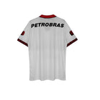 Hinchas Sportswear Store white Flamengo retro jersey with red collar and sleeve trim, featuring "PETROBRAS" on back.