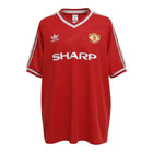 Hinchas Sportswear Store red Manchester United 1984-85 retro Adidas football jersey with Sharp sponsor and white stripes.