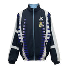 Hinchas Sportswear Store Real Madrid Kelme retro track jacket in navy black with blue and white graphic panels, embroidered crest, and zip closure.