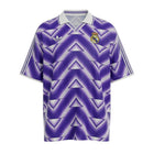 Hinchas Sportswear Store Real Madrid retro purple jersey with white Adidas stripes and geometric pattern. Features embroidered crest.