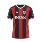 Hinchas Sportswear Store River Plate 2025/26 away jersey with red and black vertical stripes, white V-neck, and embroidered crest.